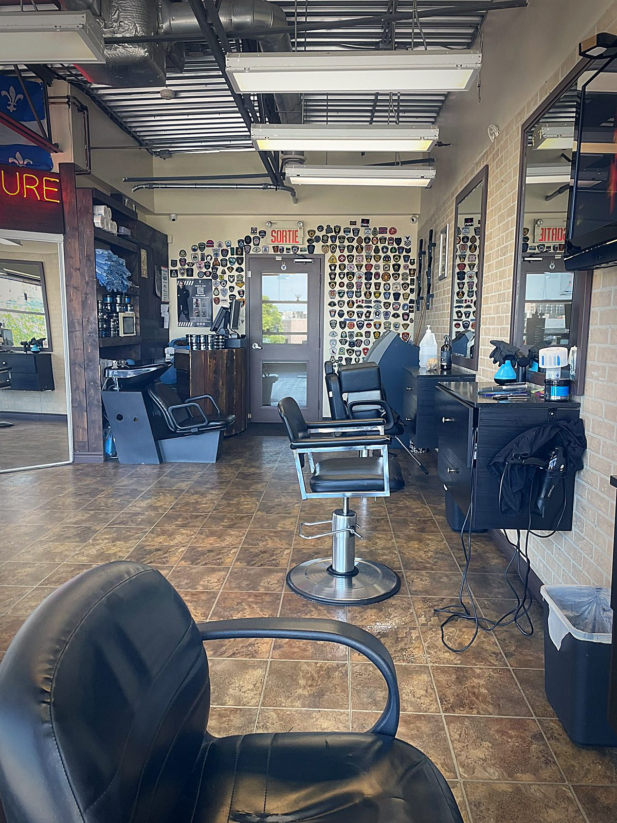 Chaises de barbier et mur d'écussons chez Coiffure Toni